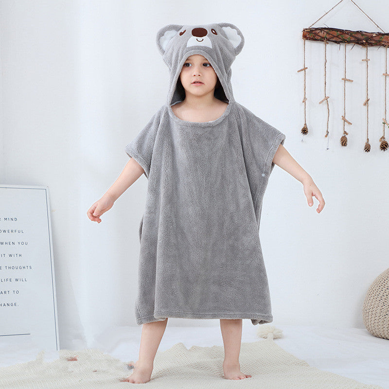 Toddler in gray koala-themed hooded towel. Infant bathrobe made from soft, antibacterial polyester for cozy post-bath wear.
