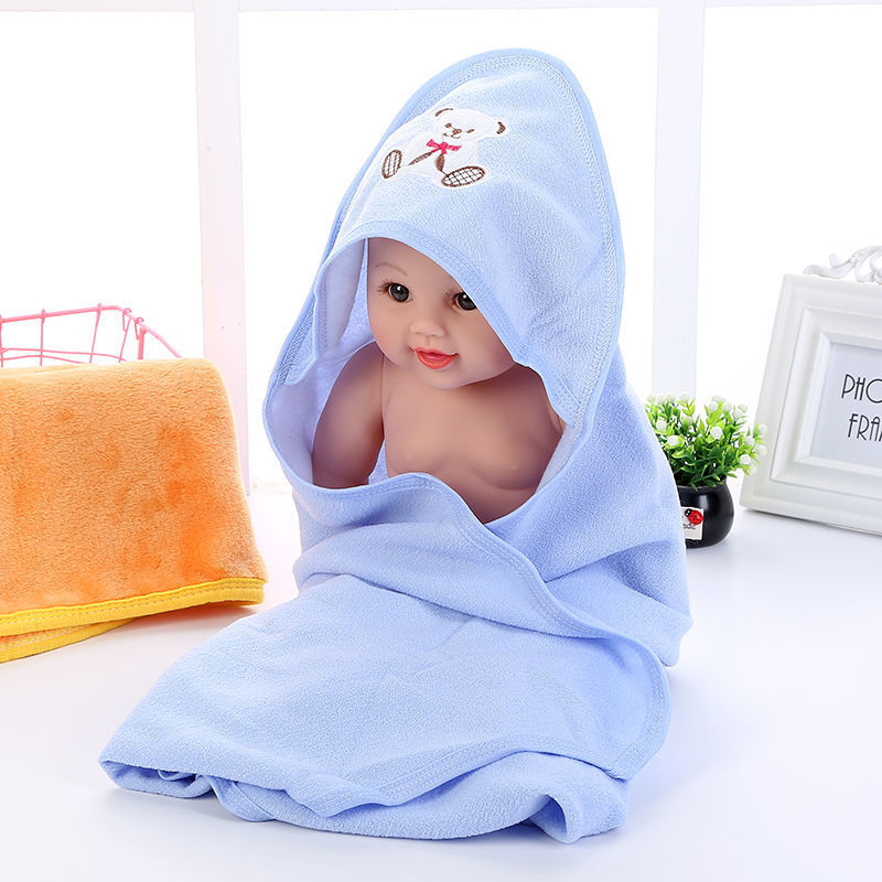 Soft baby bath towel folded next to bath essentials