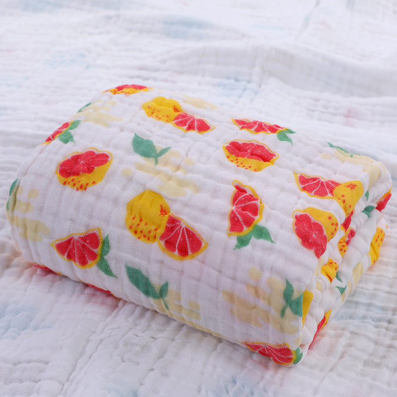 Folded cotton baby bath towel with playful cartoon swimmer print, made with soft six-layer seersucker quilt.