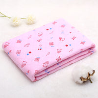 Folded pink cotton baby blanket with cartoon print. Lightweight and breathable quilt for summer and spring comfort.
